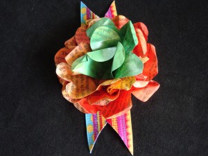 Embellished Book Flower The text still shows through this acrylic paint layer, and the colorful ribbon gives a great place for a pin.